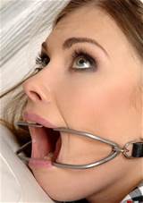 pretty girl wearing a metal dental gag that makes her mouth gape open