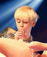 Miley Cyrus teaches fans how to give a Bj on stage